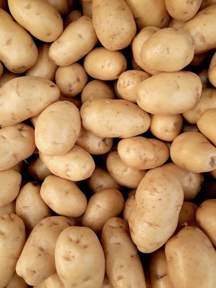 About A close-up view of fresh organic potatoes piled together, showcasing natural texture and freshness.